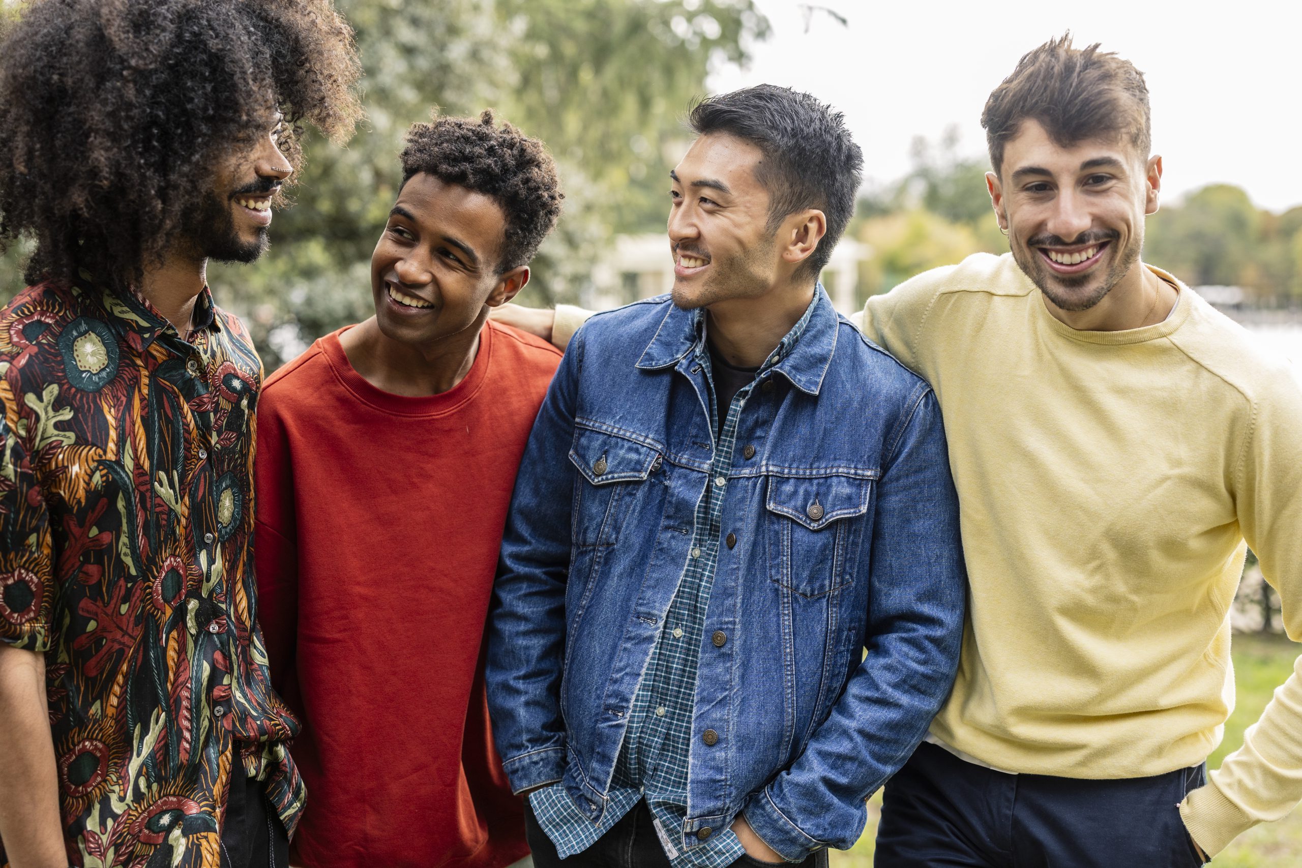 group of young adult multiracial male friends talking and laughing with each other